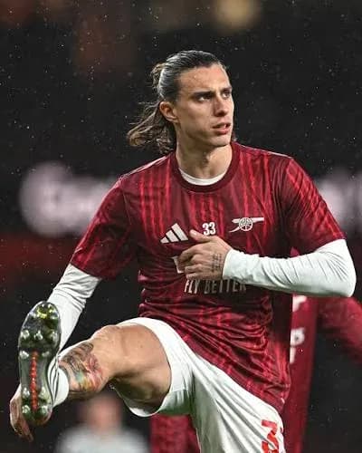 Jugador de Arsenal realizando estiramiento en el campo