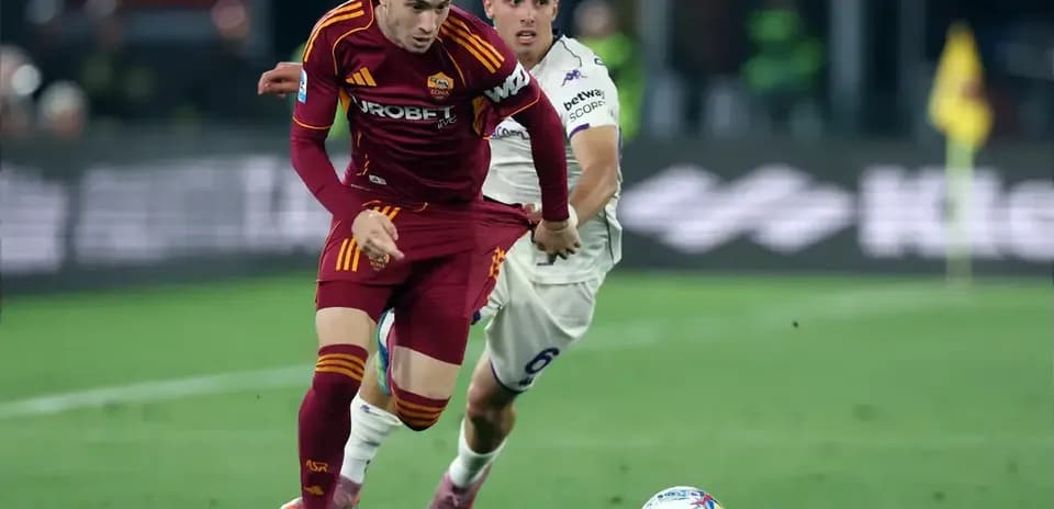 Jugador de Roma corriendo con balón en el campo