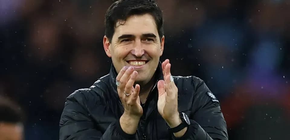 Entrenador aplaudiendo en el banquillo durante el partido