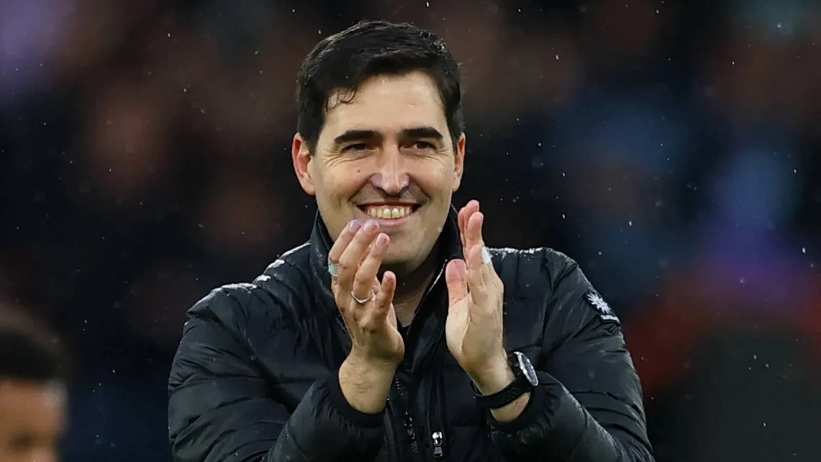 Entrenador aplaudiendo en el banquillo durante el partido