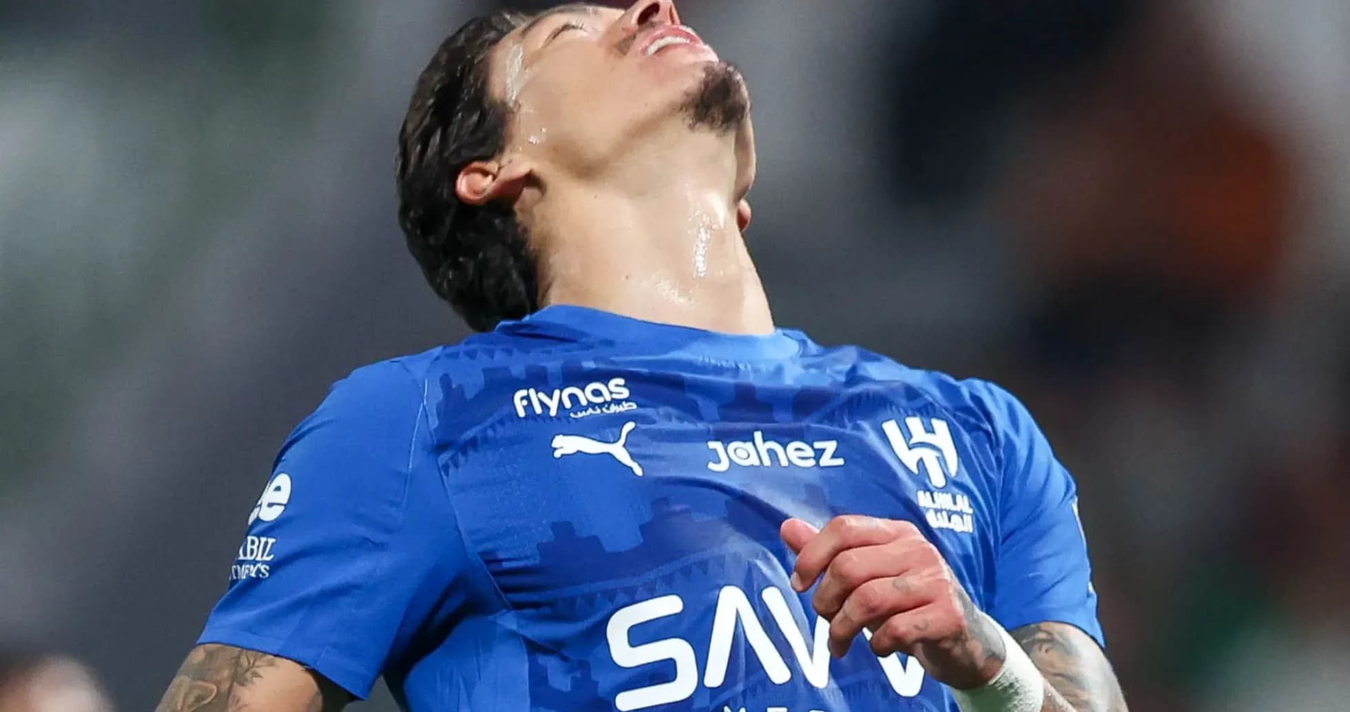 Jugador de fútbol en camiseta azul con gesto de frustración