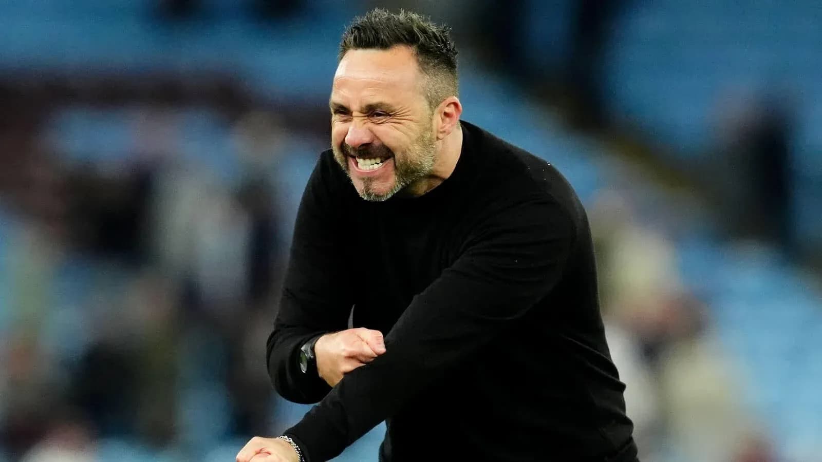 Entrenador celebrando en el banquillo del estadio