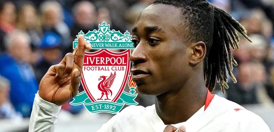 Jugador señalando con el dedo frente al logo de Liverpool