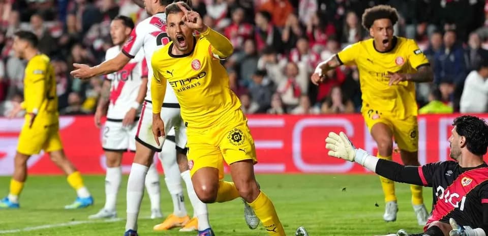 Jugador celebrando gol mientras el portero reacciona