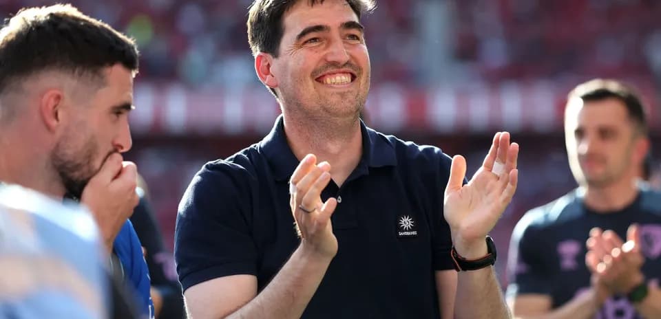 Entrenador aplaudiendo con jugadores en el fondo