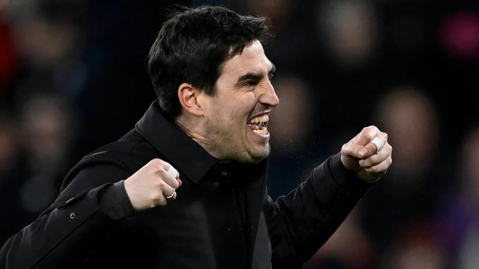 Entrenador celebrando con los puños en alto