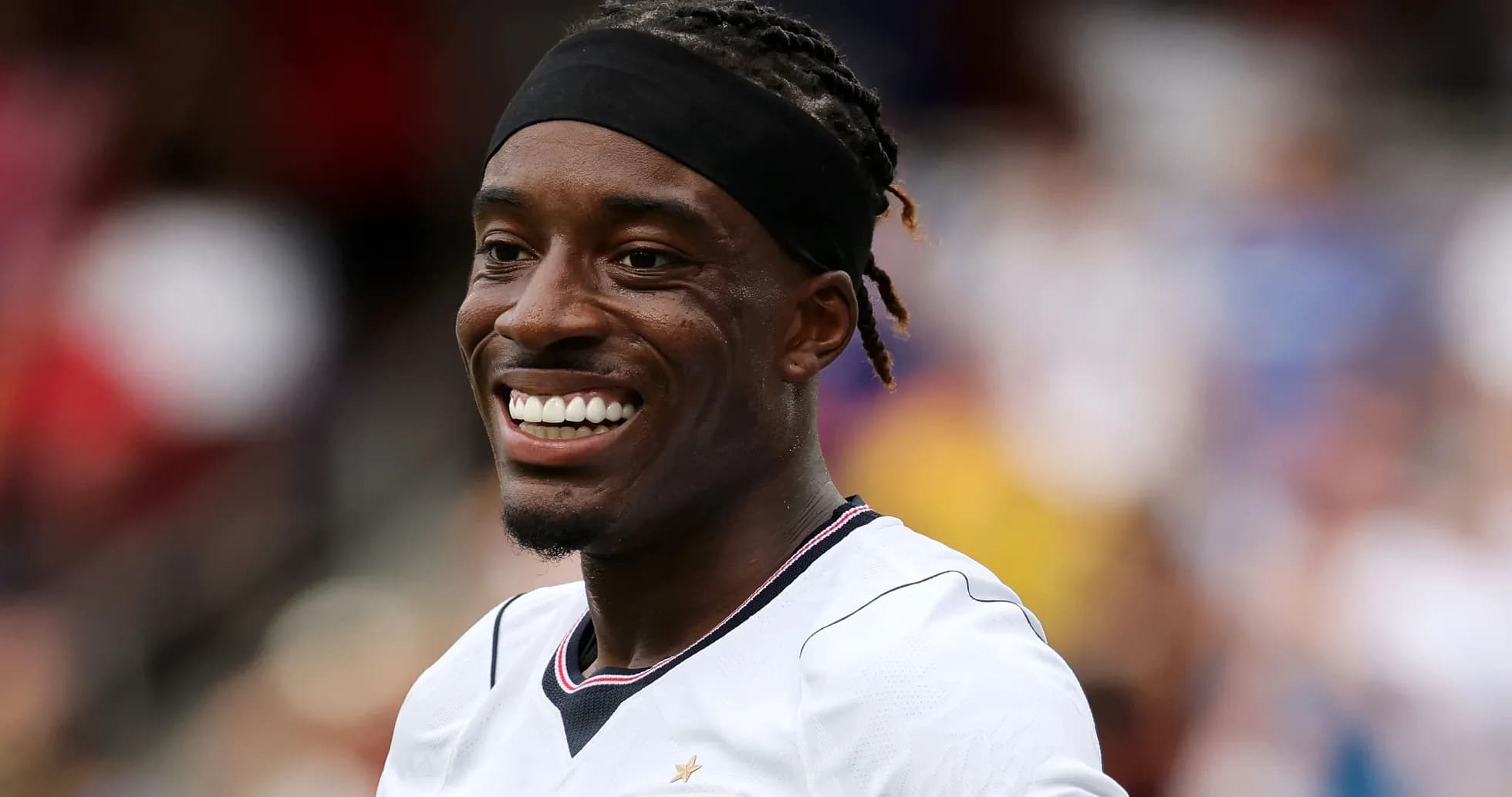 Jugador sonriendo en uniforme de fútbol blanco