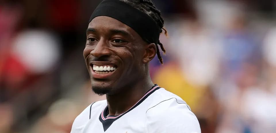 Jugador sonriendo en uniforme de fútbol blanco