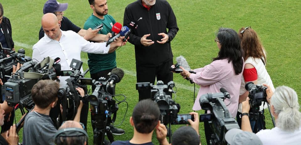 Entrenador dando declaraciones a la prensa en el campo