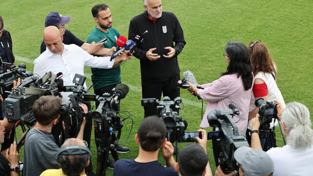 Entrenador dando declaraciones a la prensa en el campo
