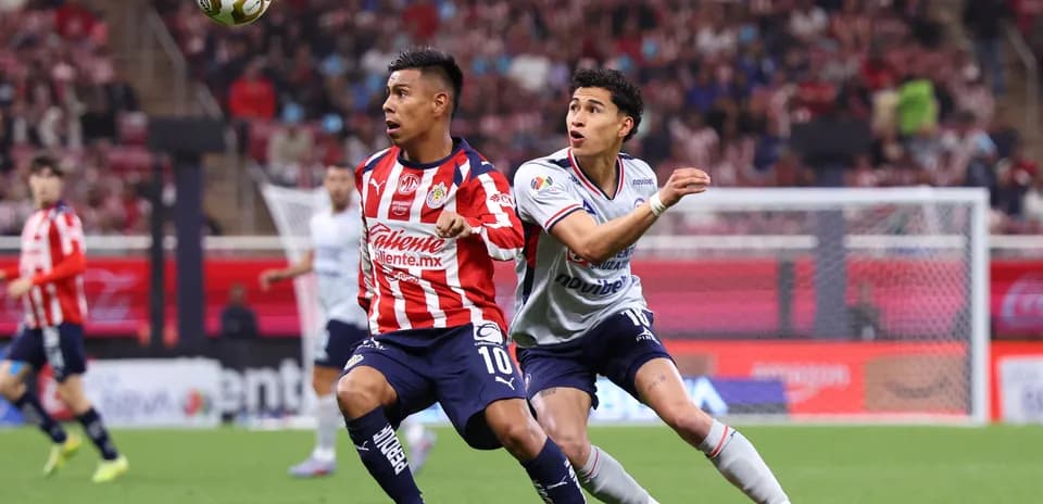 Jugador de Chivas disputando el balón con Cruz Azul