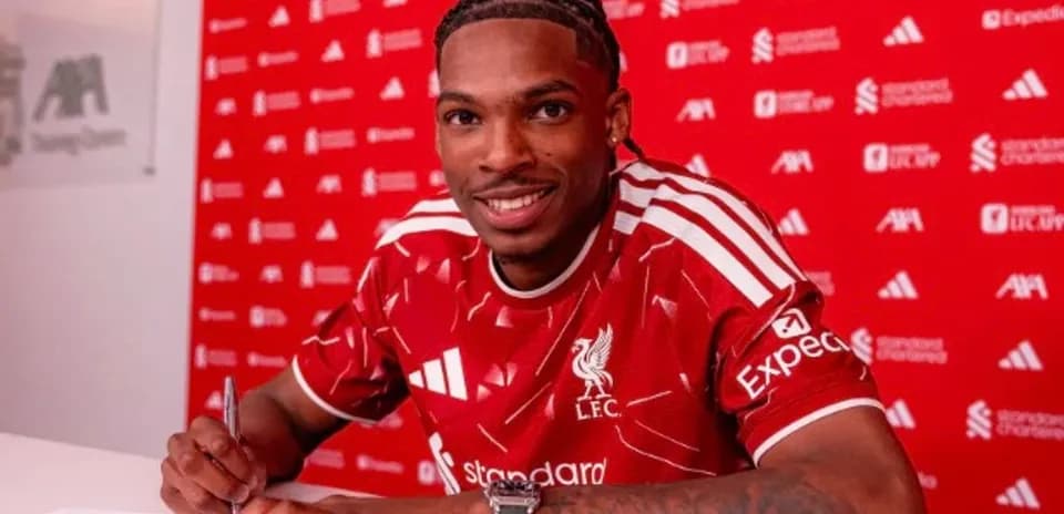 Jugador firmando contrato con camiseta de Liverpool
