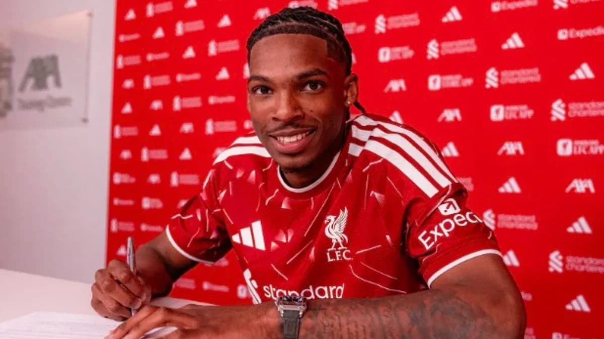Jugador firmando contrato con camiseta de Liverpool