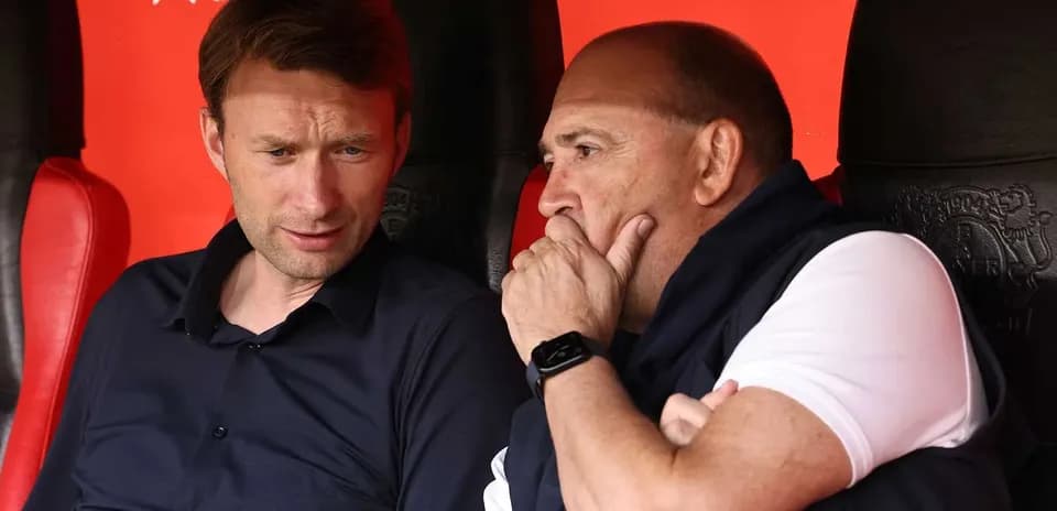 Dos entrenadores conversando en el banquillo