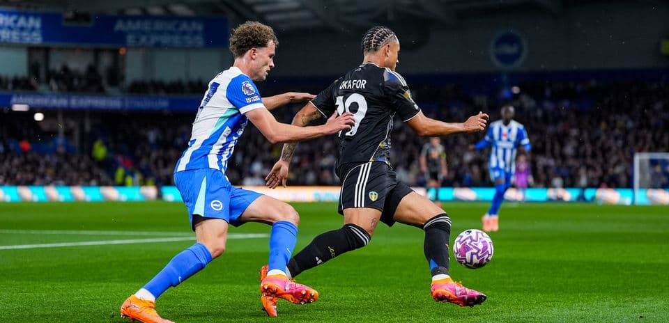 Jugador de Leeds eludiendo a defensor de Brighton
