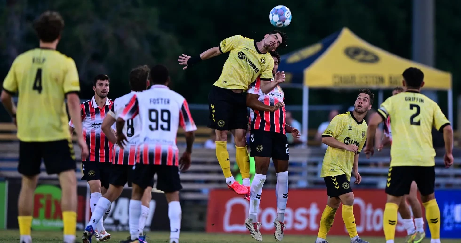 Jugadores saltando en partido de fútbol