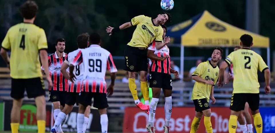 Jugadores saltando en partido de fútbol