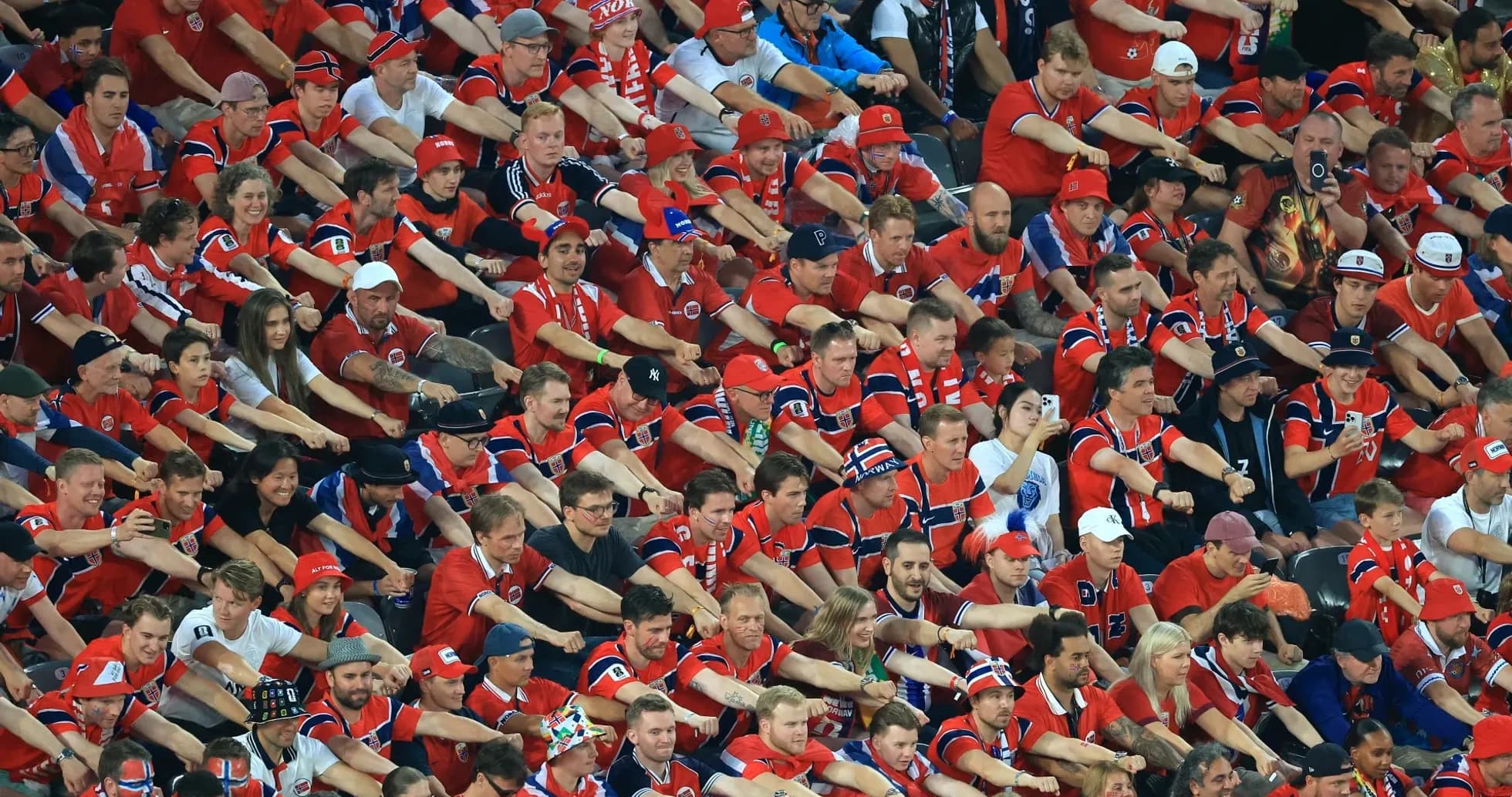 Aficionados con camisetas rojas animando en el estadio