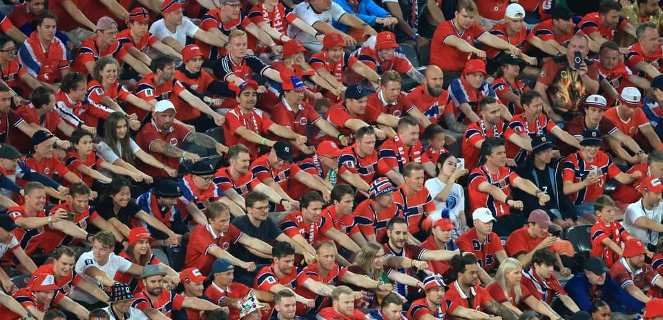 Aficionados con camisetas rojas animando en el estadio