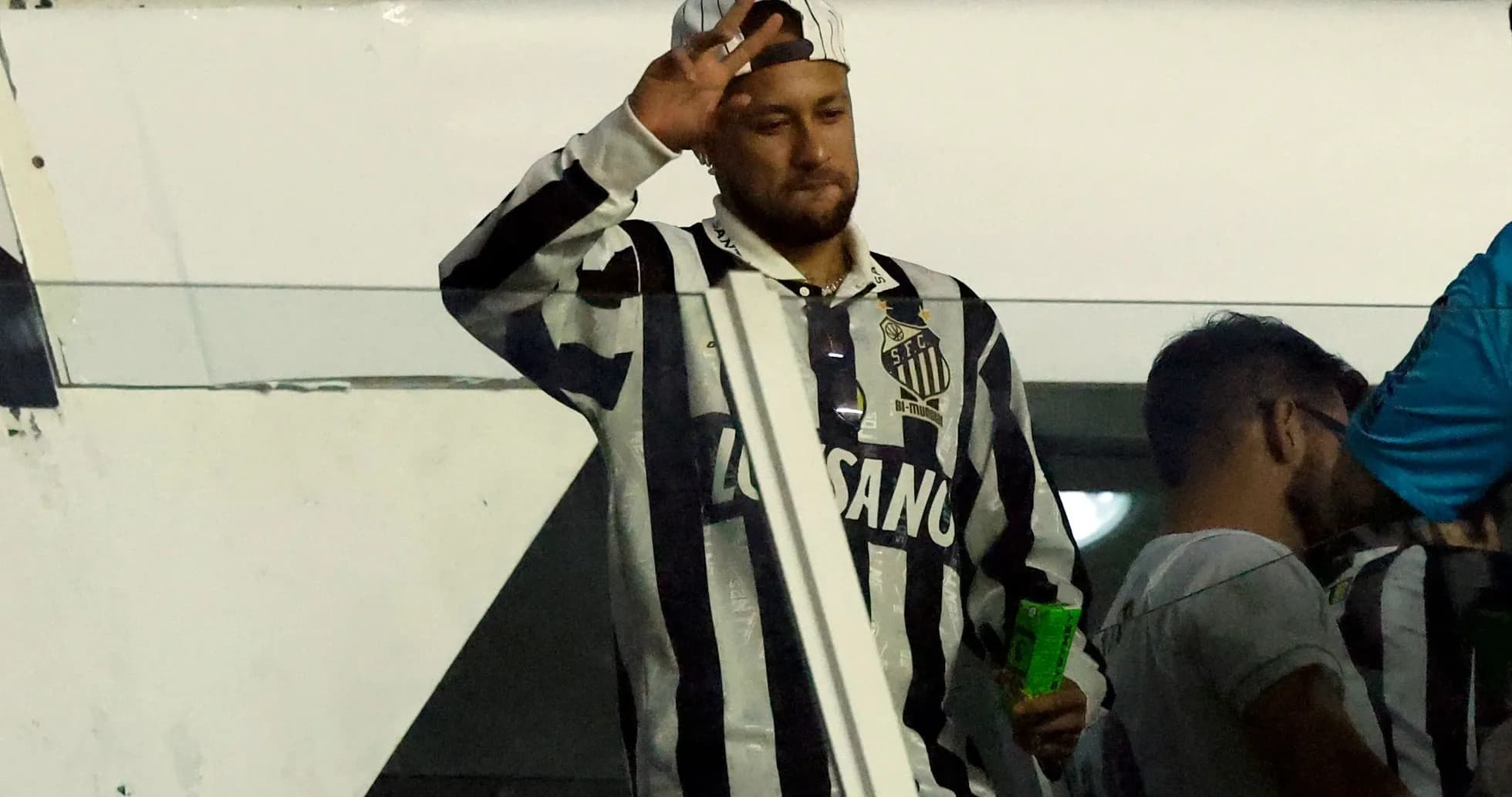 Jugador saludando desde la grada en partido