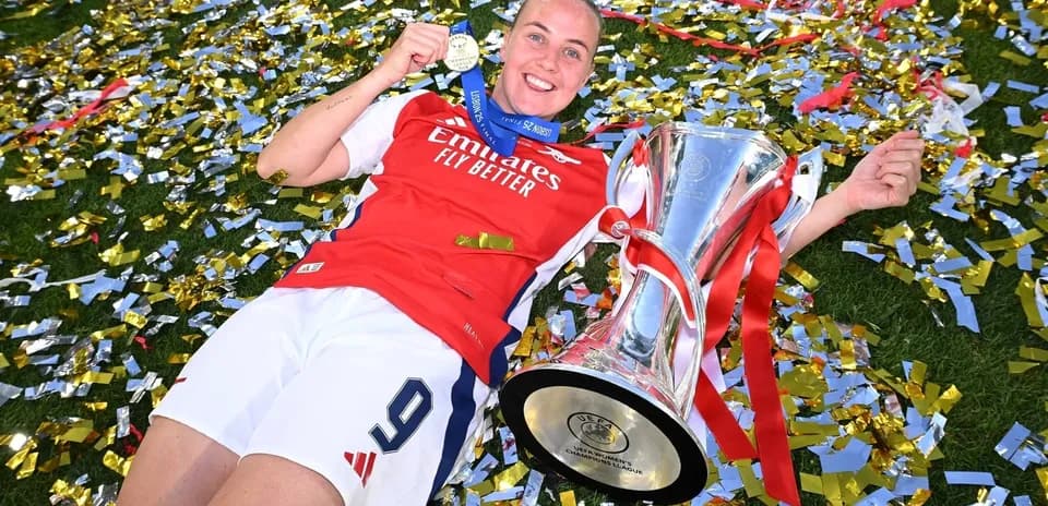 Jugadora de Arsenal celebrando con trofeo y medalla