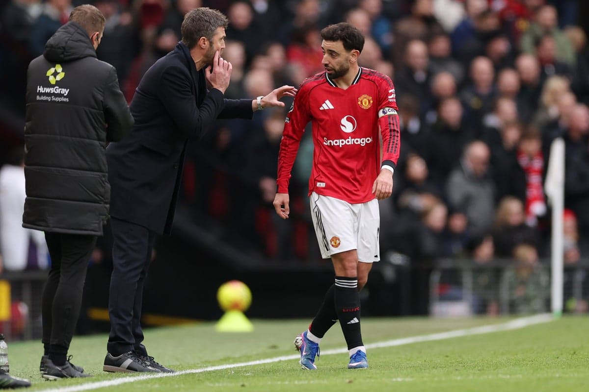 Entrenador dando instrucciones a jugador de Manchester United