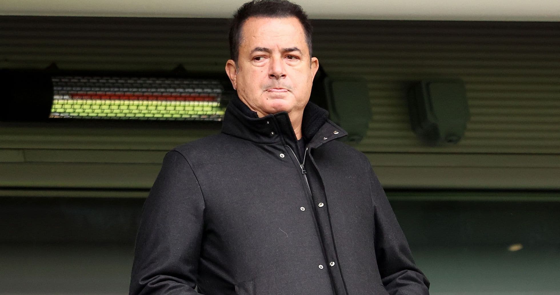 Hombre en abrigo negro en el estadio