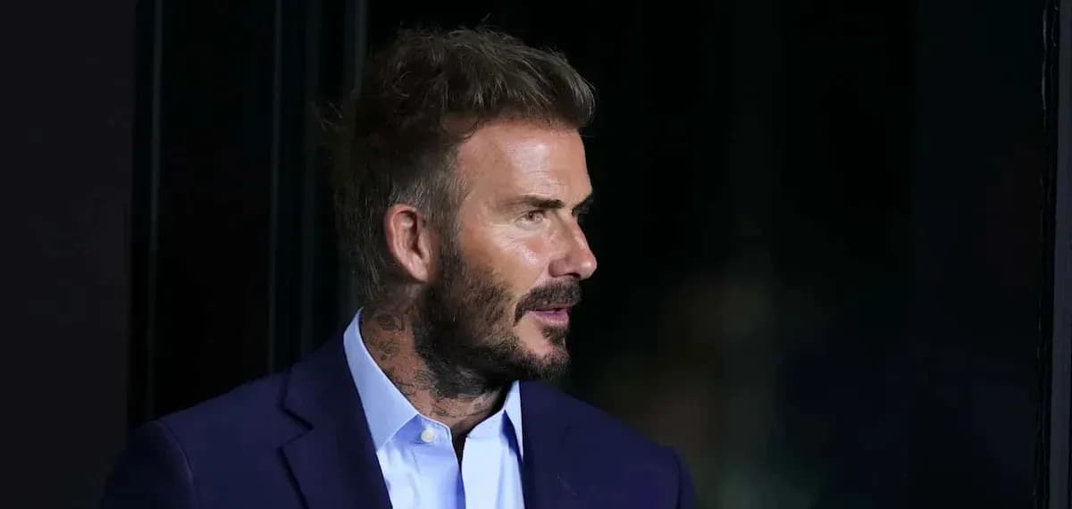 Hombre con cabello corto y barba en traje oscuro