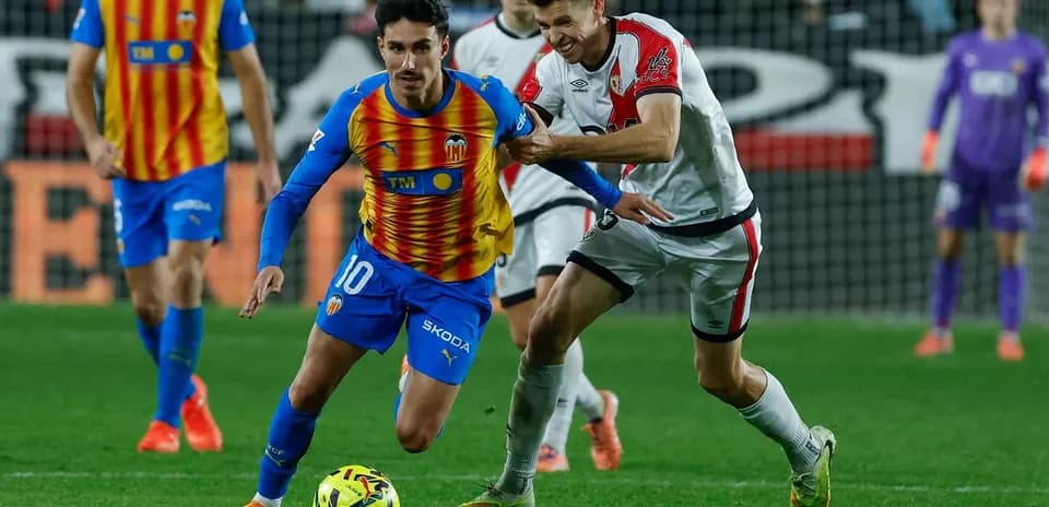 Jugador de Valencia driblando a rival de Rayo Vallecano