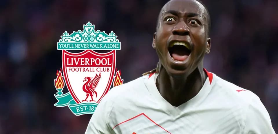 Jugador celebrando con el escudo del Liverpool de fondo