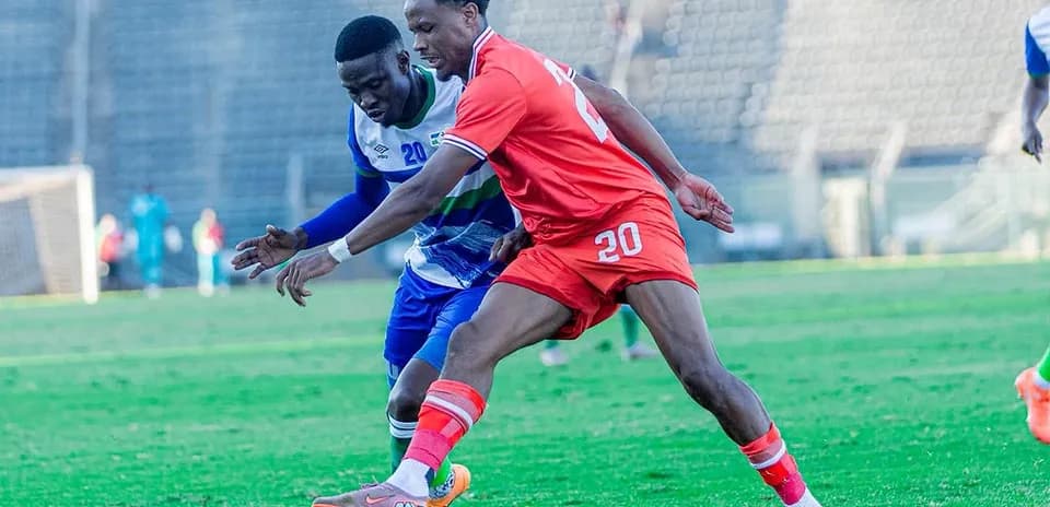 Jugador en rojo luchando por el balón con adversario