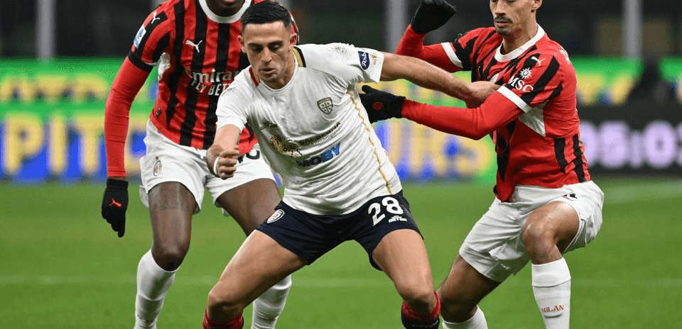 Jugadores de AC Milan y Cagliari disputando el balón