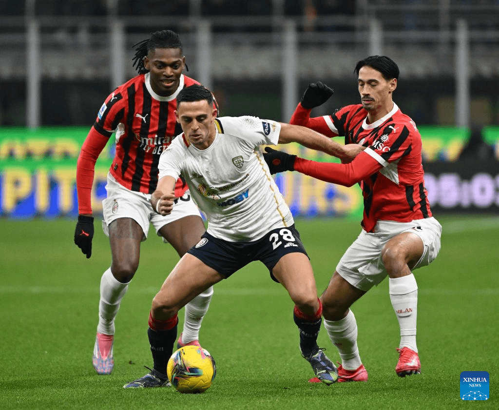 Jugadores de AC Milan y Cagliari disputando el balón