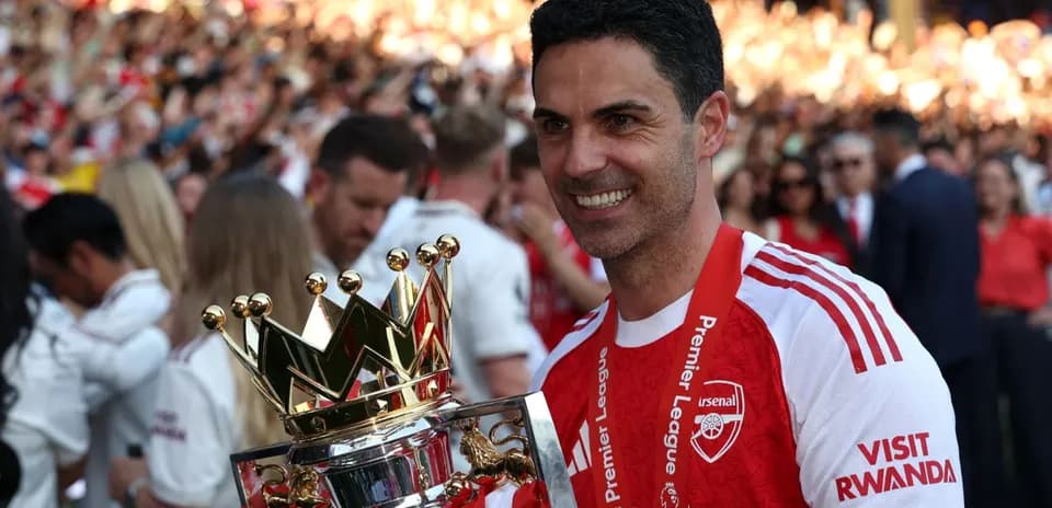 Entrenador de Arsenal sosteniendo trofeo de Premier League
