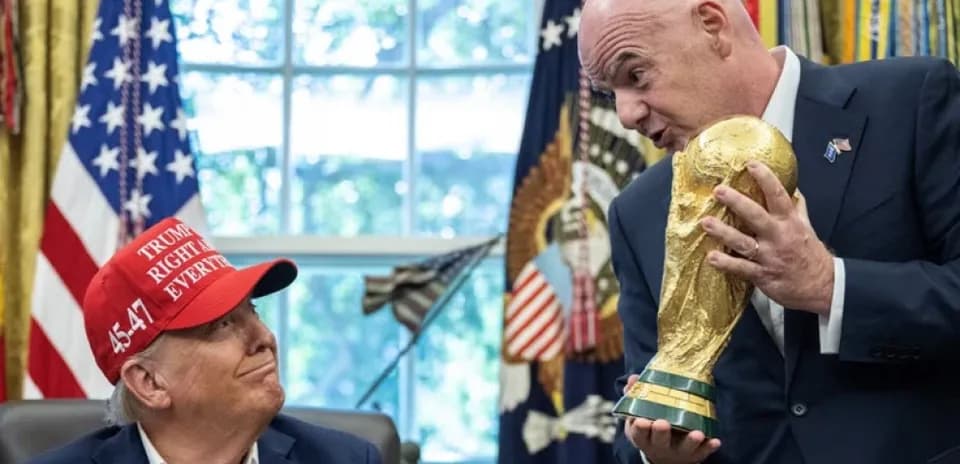 Persona sosteniendo la Copa del Mundo en oficina
