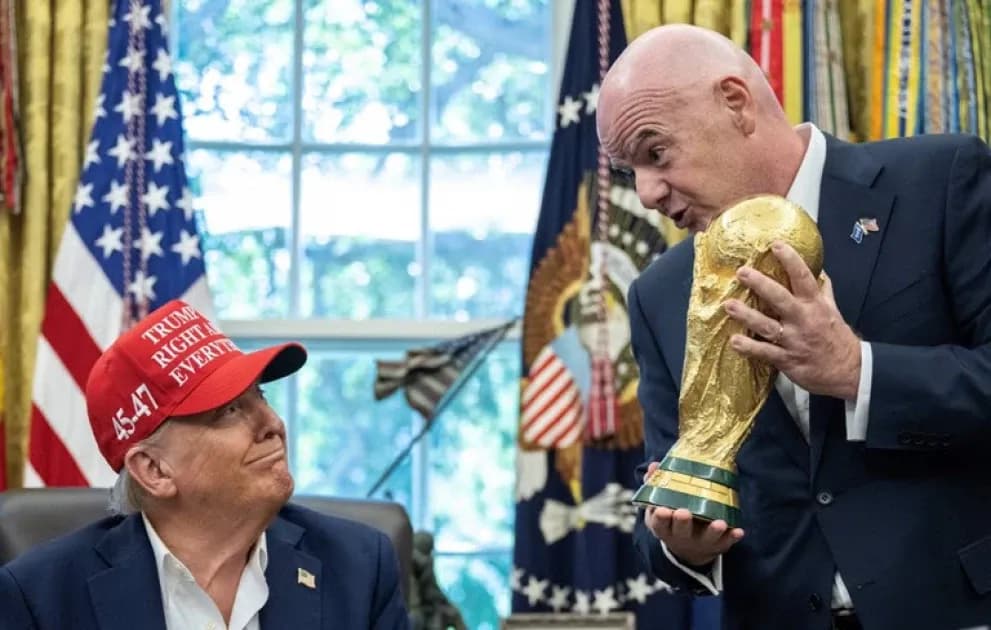 Persona sosteniendo la Copa del Mundo en oficina