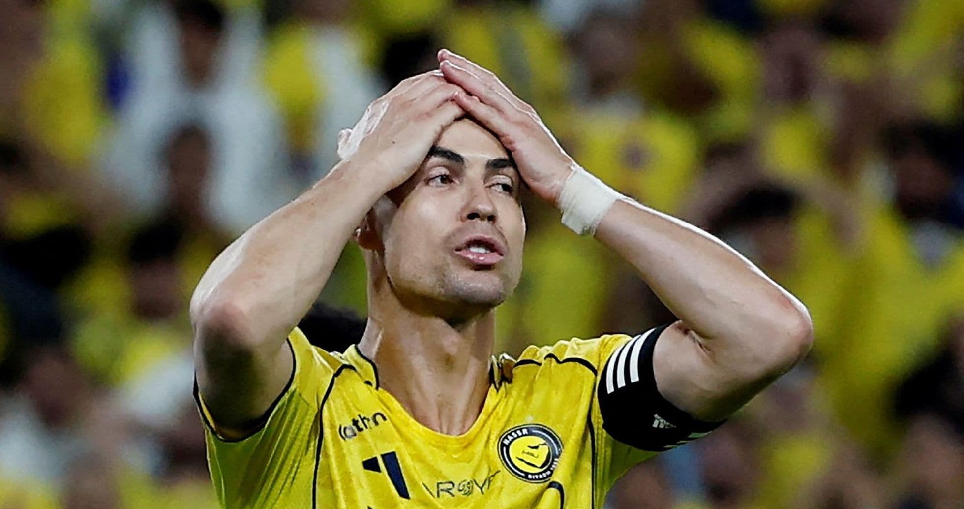 Jugador con camiseta amarilla sosteniendo la cabeza