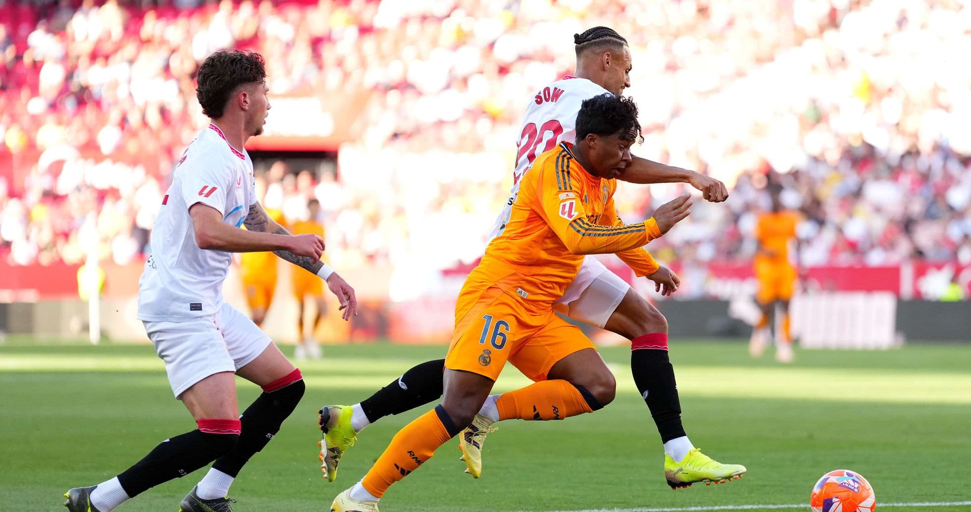 Jugadores de Sevilla y Real Madrid compiten por el balón