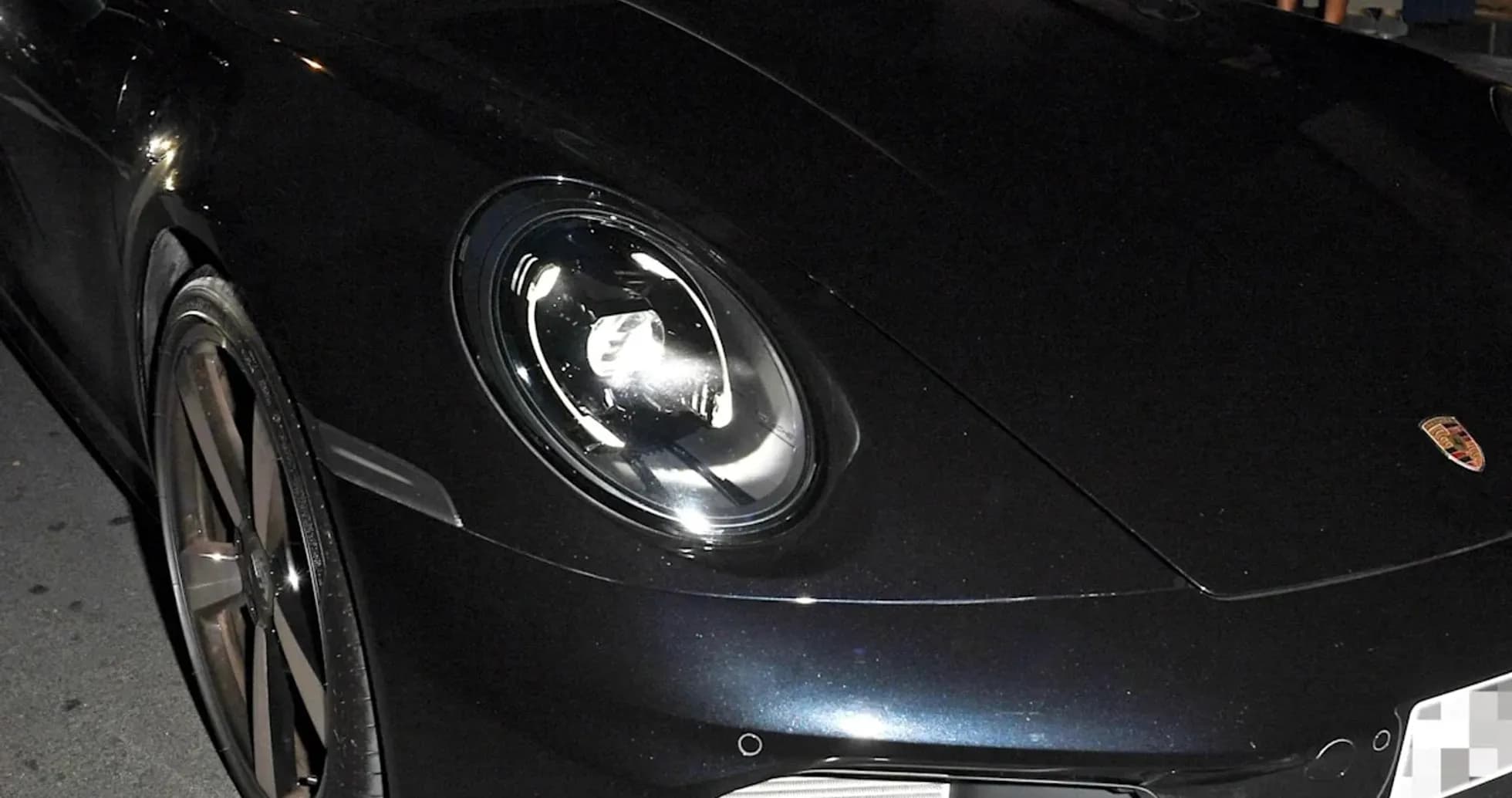 Dos hombres dentro de un Porsche negro en la calle