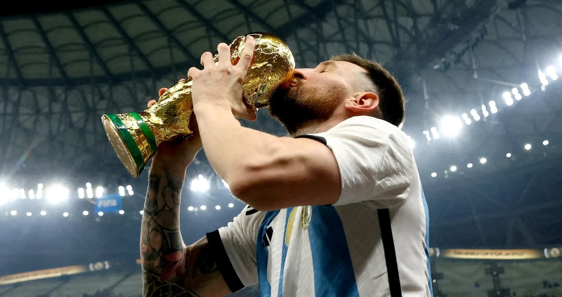 Jugador levantando y besando el trofeo de la Copa Mundial