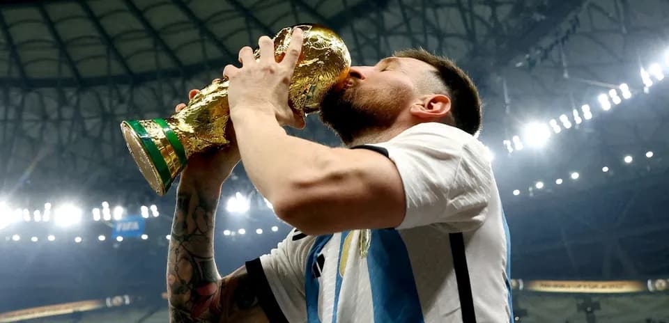 Jugador levantando y besando el trofeo de la Copa Mundial