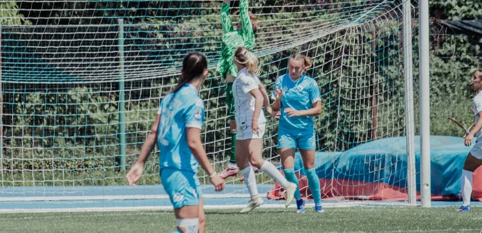 Portera atrapando el balón en un partido