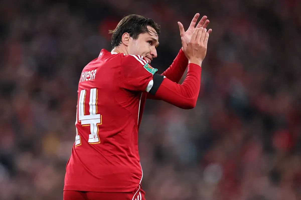 Jugador aplaudiendo con camiseta roja en el estadio