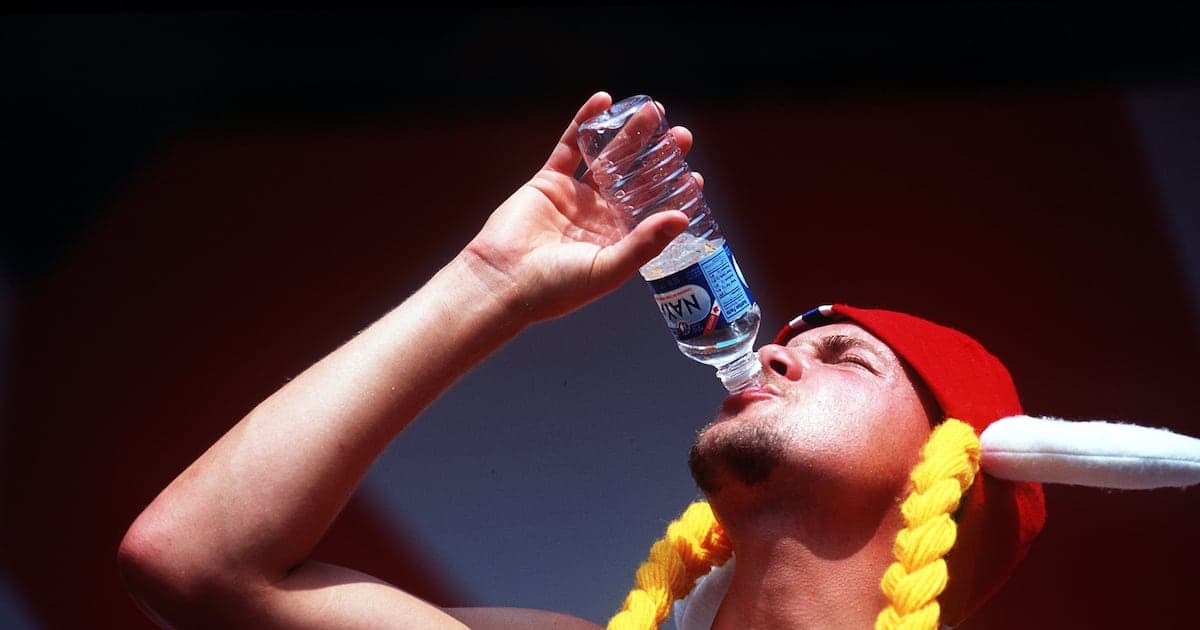 Hombre bebiendo agua de botella durante evento