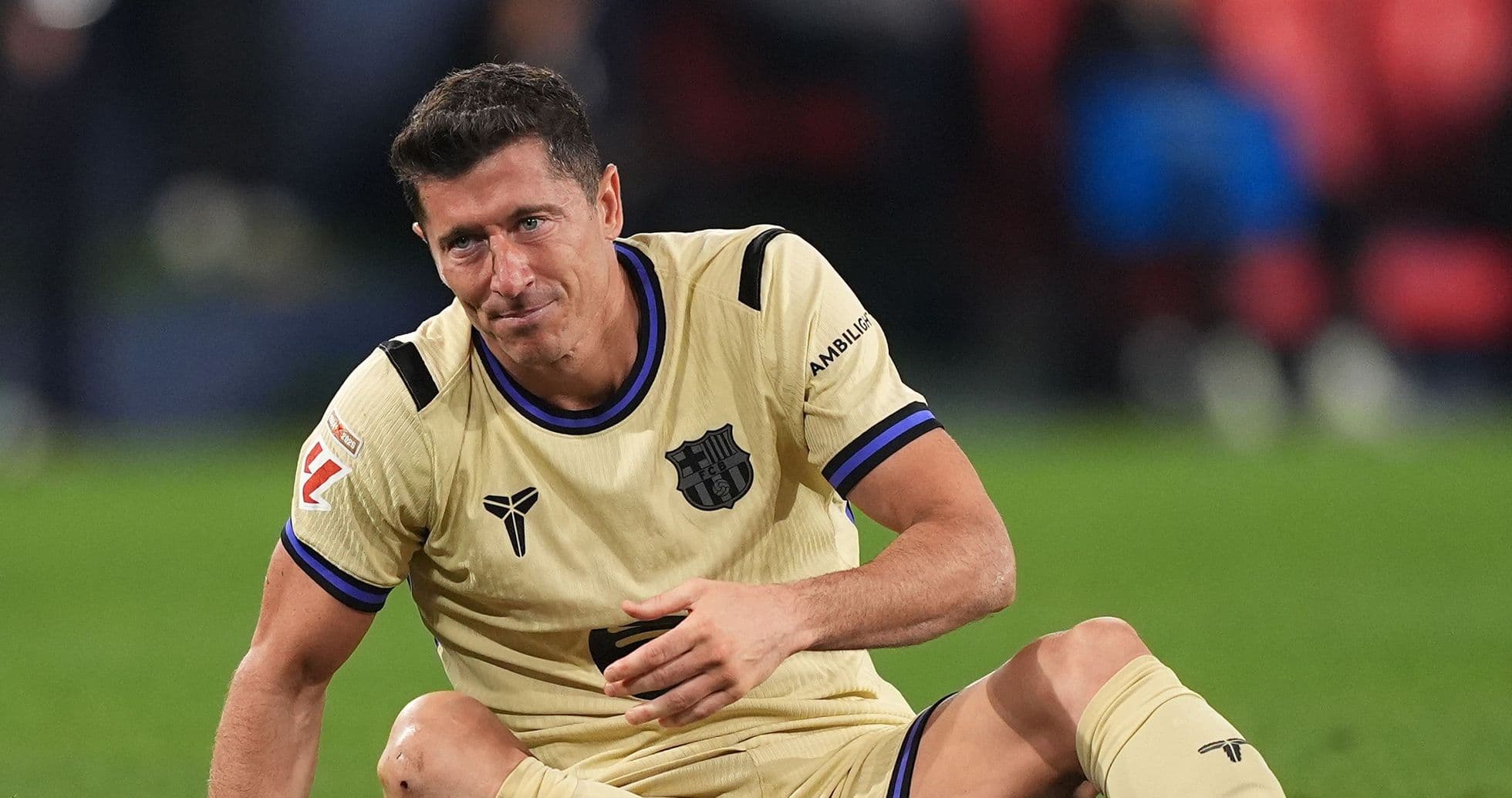 Jugador de fútbol sentado en el campo tras partido